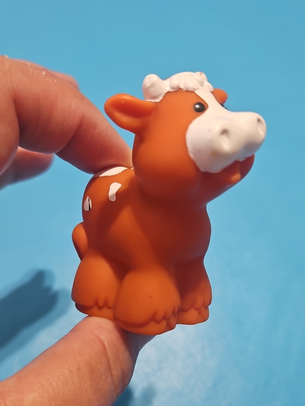 Fisher-Price Little People brown and white spotted cow figure.